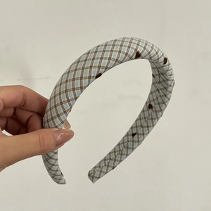 Detail of light blue checkered headband with heart patterns and thick padding design
