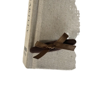 French style brown ribbon bow hair clip with pearls on a vintage linen book background