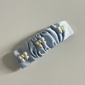 Fermaglio per capelli a pieghe azzurro con tre fiocchi di resina bianca stile dolce