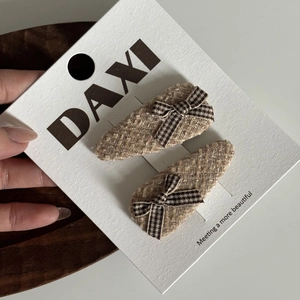 Détail de barrettes BB en tweed avec nœuds à carreaux marron sur carte blanche