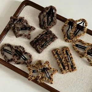 Leopard print plush hair clip set in star and heart shapes on a linen tray