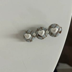 Detail of sweet plaid hair clip with heart pearls and blue vintage checkered fabric