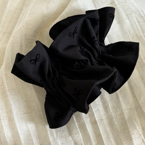 Détail du chouchou noir surdimensionné avec motif de papillon imprimé uniforme