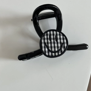 Glänzende schwarze Haarklammer mit einem stilvollen schwarz-weißen Karomuster-Smiley