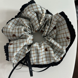 Close-up of large plaid hair scrunchie with brown hearts and black lace trim detail
