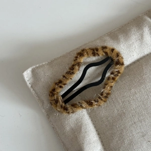 Close-up of leopard print plush BB hair clip showing fuzzy texture and wavy metal clamp
