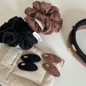Detailed view of jacquard fabric hair scrunchies and oval clips with metallic logo accents
