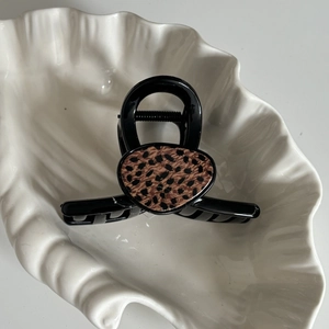Dettaglio della pinza per capelli con stampa leopardata su vassoio in resina di alta qualità