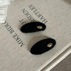 Pair of minimalist black fabric oval hair clips with gold love engraving in wasteland style