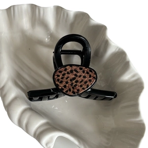 Elegante pinza per capelli nera con inserto leopardato su vassoio a forma di conchiglia