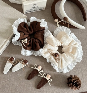 Detailed close-up of vintage brown and beige floral hair accessories set with lace textures