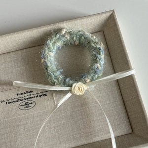 Detailed close-up of handmade crochet hair clip with a ribbon bow and yellow fabric rose