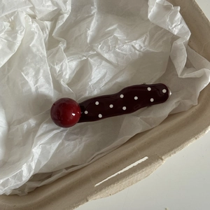 Sweet red polka dot hair clip with pearl-like ball decoration for women on white paper