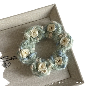 Handmade crochet floral hair clip with light green and blue yarn and white roses