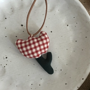 Détail d'un pendentif tulipe fait main en tissu à carreaux avec cordon marron