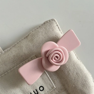 Detail of pink rose acetate hair clip with a ceramic gloss finish on canvas