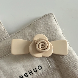 Detailed close-up of a French beige acetate flower hair clip with a layered petal design