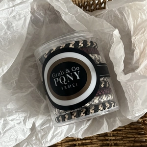 Elastic hair ties in multicolored woven style stored in a portable transparent jar