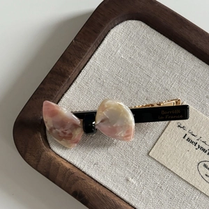 Pink marble texture bow hair clip with gold Barrette La France lettering on wood tray
