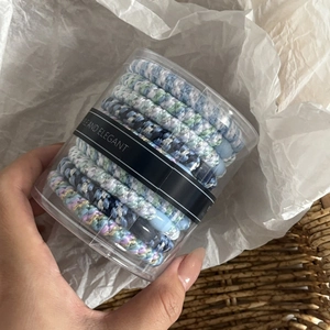 Close-up of blue and white braided high-elastic hair ties in elegant clear packaging