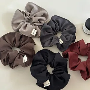 Minimalist fabric scrunchies set in neutral colors with handmade labels for women