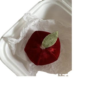 Creative red velvet apple hair claw clip with golden leaf detail on white tissue