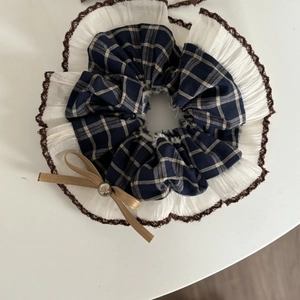 Navy blue plaid scrunchie with lace edge and brown bow featuring a pearl detail