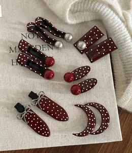 Detail of vintage burgundy polka dot hair clips in various shapes and artistic retro styles