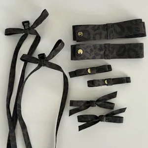 Macro shot of dark leopard print hair clips and bow set with golden metallic details