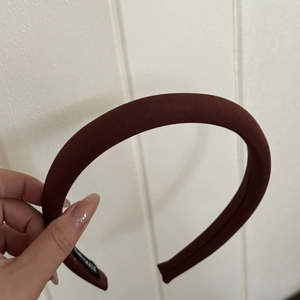 Détail d'un serre-tête en éponge de couleur unie montrant la texture sergée et l'étiquette