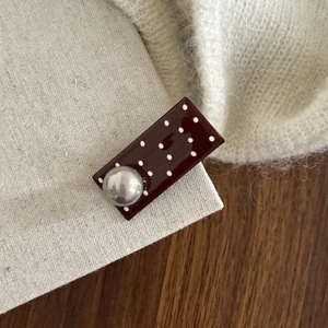 Vintage chocolate polka dot hair clip with silver ball on soft beige linen fabric