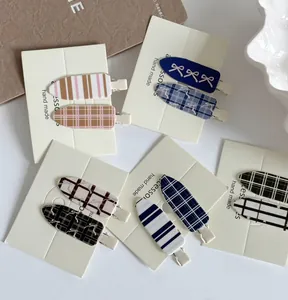 Détail de cinq paires de barrettes à cheveux à carreaux bleus et nœuds sur carton