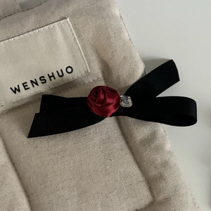 Elegant black silk bow hair clip featuring a dark red rose and crystal embellishment