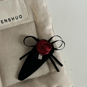 Gothic dark red satin rose hair clip with black ribbon bow on minimalist background