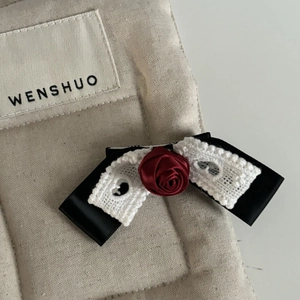 Handmade black bow hair clip with white lace trim and red satin rose center floral accent