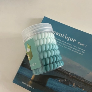 Élastiques à cheveux spirale en dégradé de vert dans un pot transparent avec étiquette