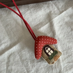Detail eines handgefertigten Hausanhängers aus Stoff mit rotem Polka-Dot Dach