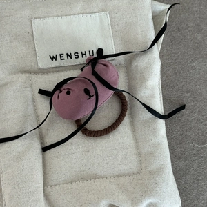 Détail d'accessoire pour cheveux en peluche chien fait main sur pochette coton