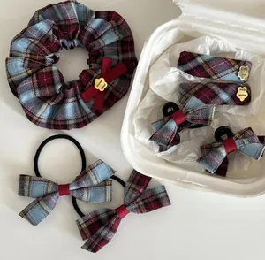 Vue à plat d'accessoires de cheveux à carreaux britanniques avec breloques dorées