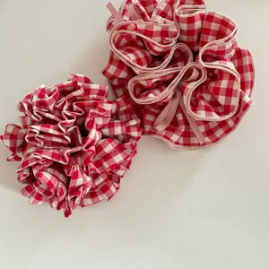 Detail of red and white plaid scrunchies featuring a large puff and a bow design