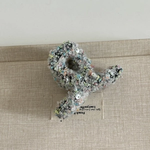 Détail de la pince à cheveux en tweed avec paillettes colorées et tissu laineux