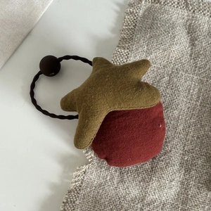 Detail von Plüschstern und Kugel Design auf hochelastischem braunem Haargummi für Kleinkinder