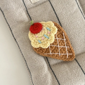 Detailansicht der handgestrickten Eistüte-Haarklammer mit bunten Streuseln und Kirsche