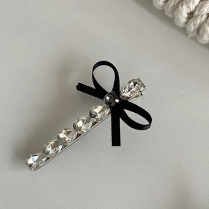 Detail of French vintage hair clip with grey crystal bow and silver metal plating