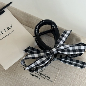 French vintage hair claw clip with black and white plaid ribbon bow on linen background