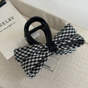 Elegant black and white plaid bow hair claw clip with glossy finish for women's hairstyle