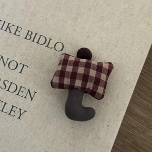 Detail of a handmade 3D umbrella hair clip featuring brown checkered fabric and plush texture