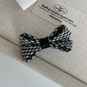 Close-up of black and white houndstooth bow hair clip with French vintage fabric texture