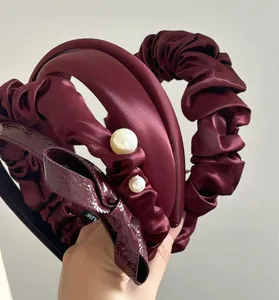 Detailed set of three cherry red satin and faux pearl headbands with pleated textures