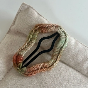 Gros plan sur la barrette étoile en laine crochetée à la main aux tons vert et marron